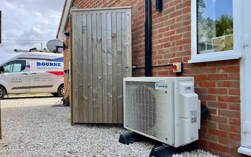 Daikin outdoor unit with a screened bin store and company van behind