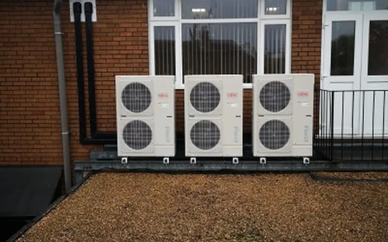 Three large outdoor units on a gravel flat roof beside a brick building (Durrington case study)