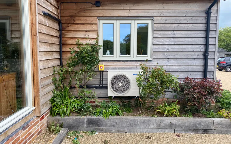 Installing New Air Conditioning System: outdoor unit on a timber-clad home