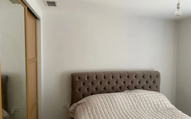Domestic ducted air conditioning grille in a bedroom