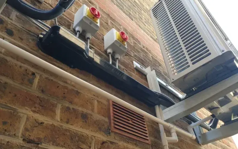 Outdoor air conditioning unit on a wall bracket with pipework