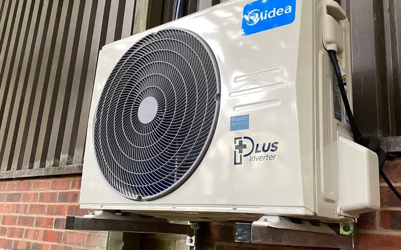 Midea outdoor unit on a wall bracket against brick
