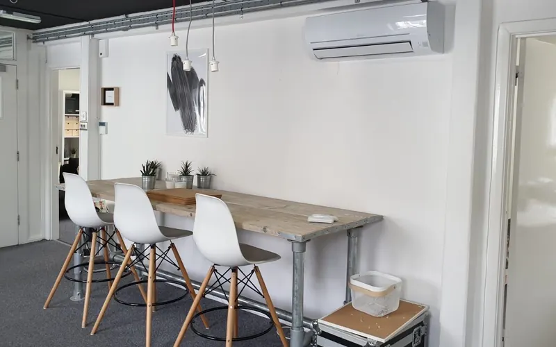 White wall-mounted unit in Brighton offices over a table