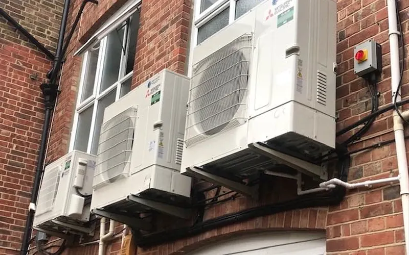 Mitsubishi outdoor units on brackets on a brick wall, Brighton